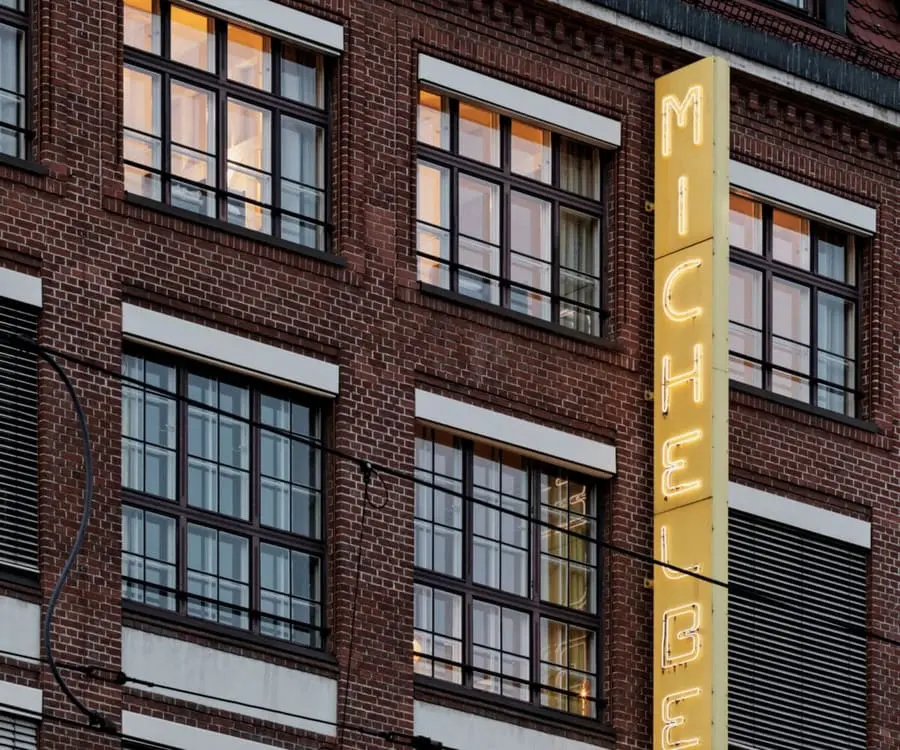Neon-Schild „MICHELBERG“ an der Backsteinfassade des Michelberger Hotels.